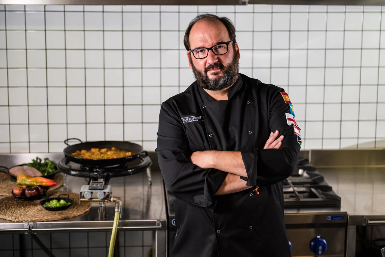 Carlos Ripoll en su cocina, junto a una paella recién hecha.